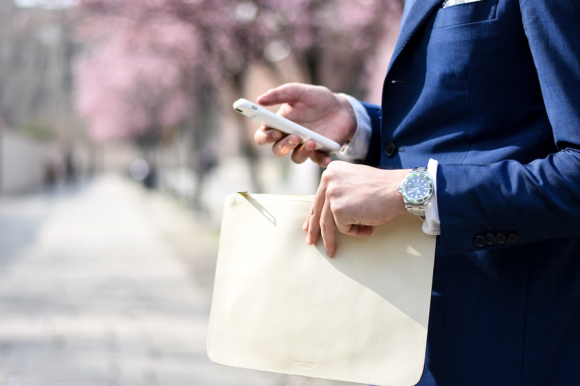 Close up of suited buisness man holding a phone and a document